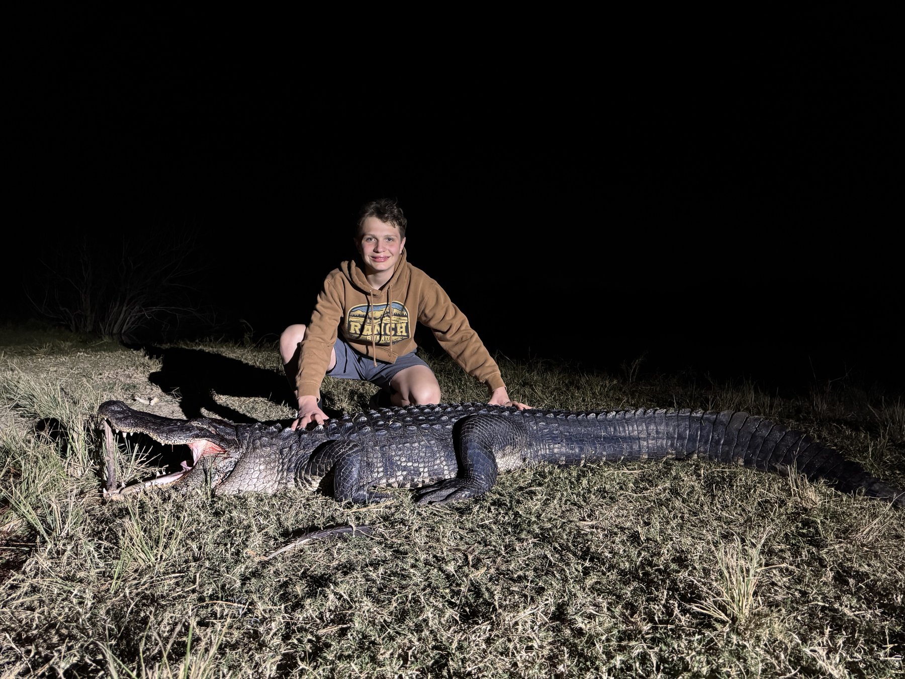 Kid with large gator at night Wild Florida Hunts
