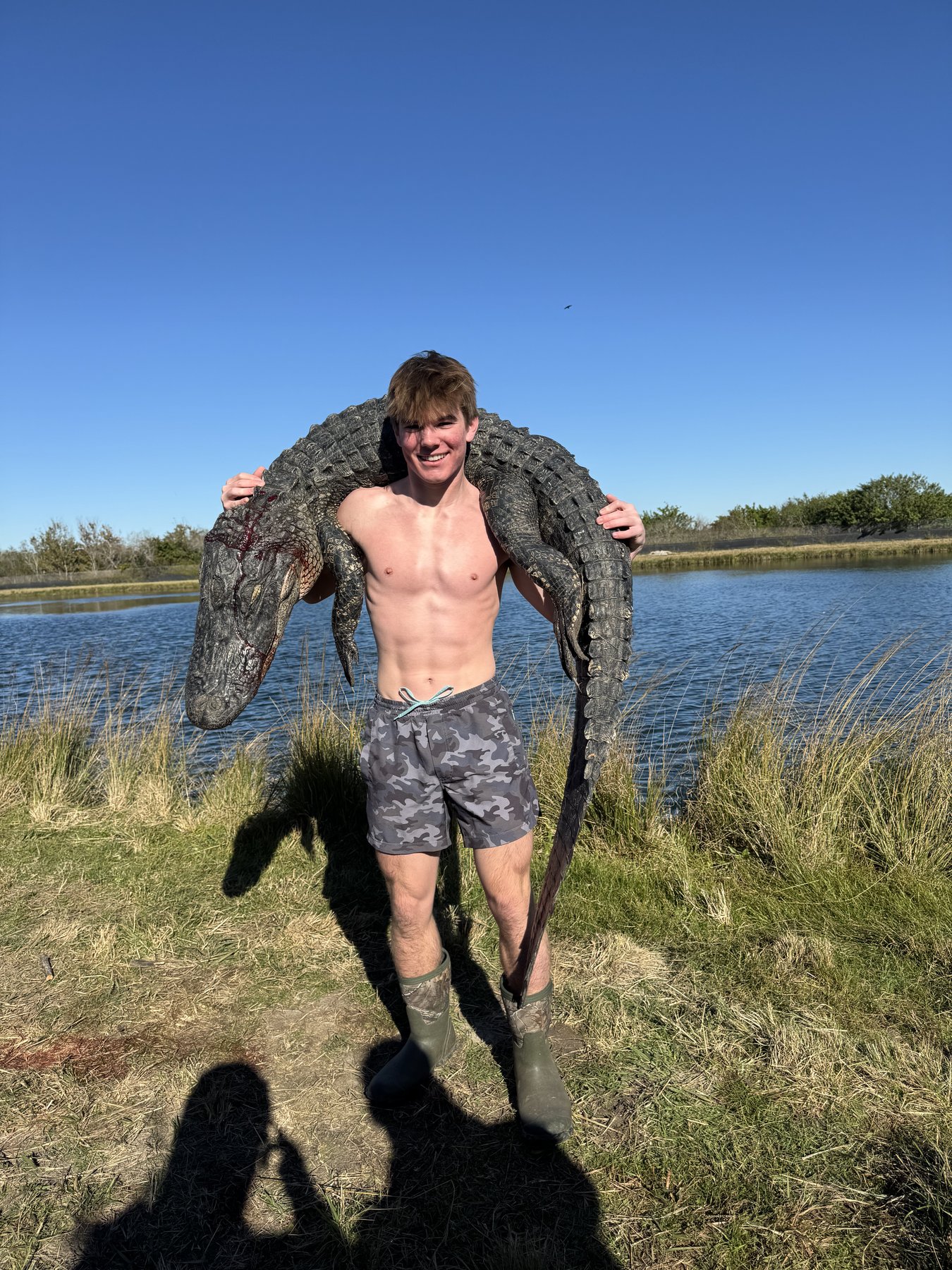 Hunter carrying gator over shoulders Florida